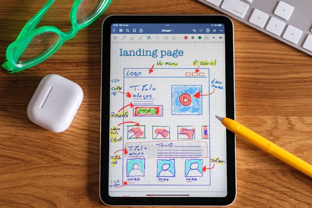 Tablet with a website wireframe sketch on a wooden desk